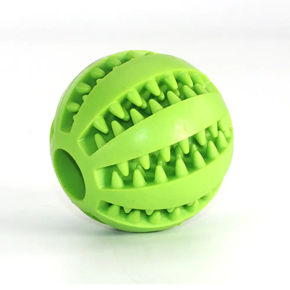 Red dog toy ball with textured surface and small treats inside, surrounded by other colorful toy balls on a white background.