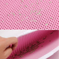 Close-up of pink textured surface with small green particles and a hand holding the material.