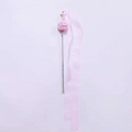 Pink hair tie with decorative elements on a light pink background