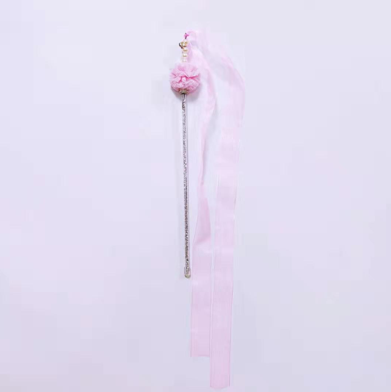 Pink hair tie with decorative elements on a light pink background