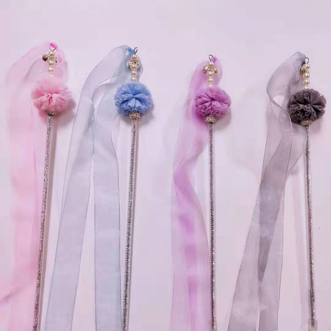 Decorative hair sticks with colorful pom-poms and ribbons on a light background