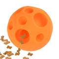 Orange dog toy with holes and scattered dog treats on a white background